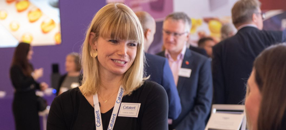 Female pharma professional talking with person at CPHI event