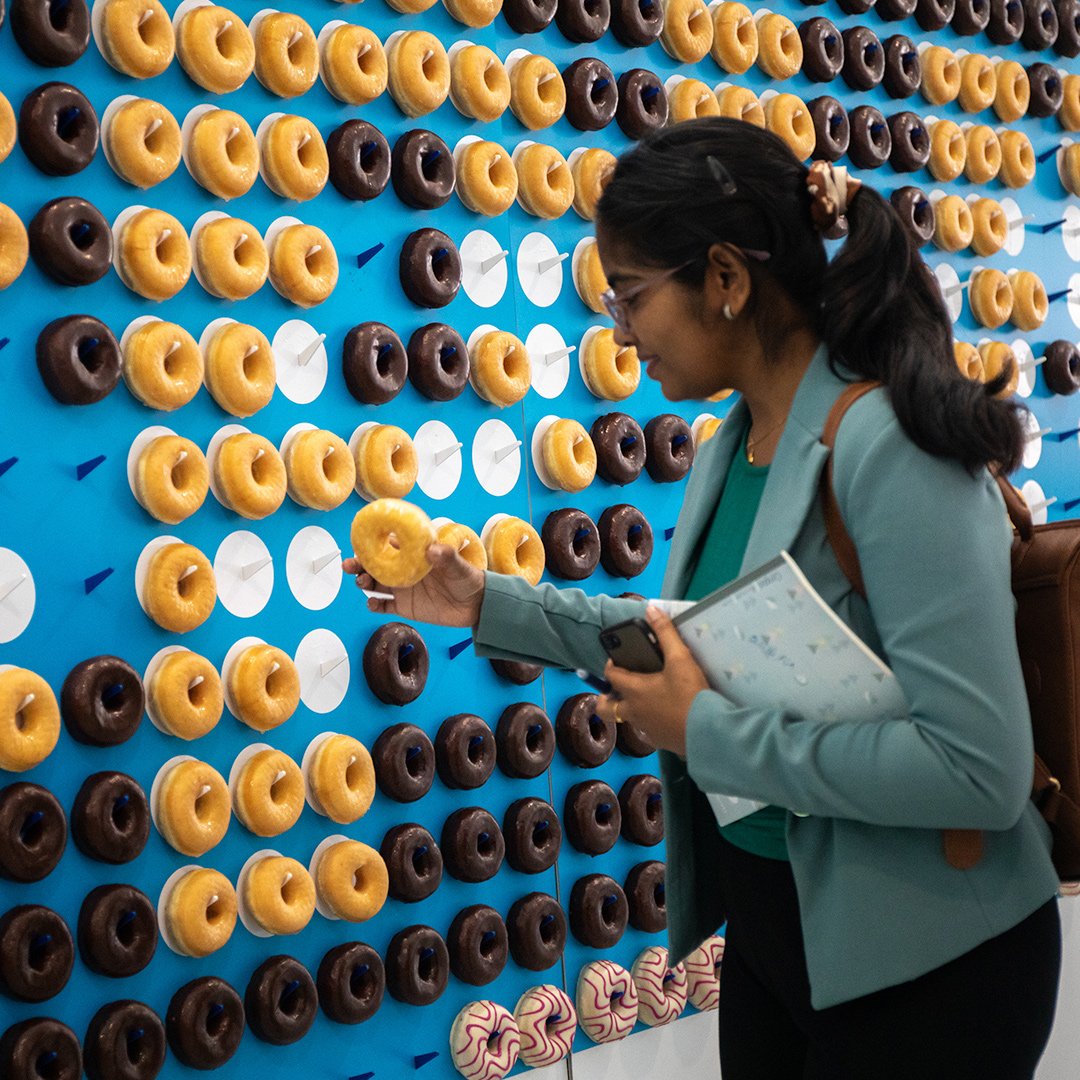 Pharma professional in front of donut wall at CPHI event